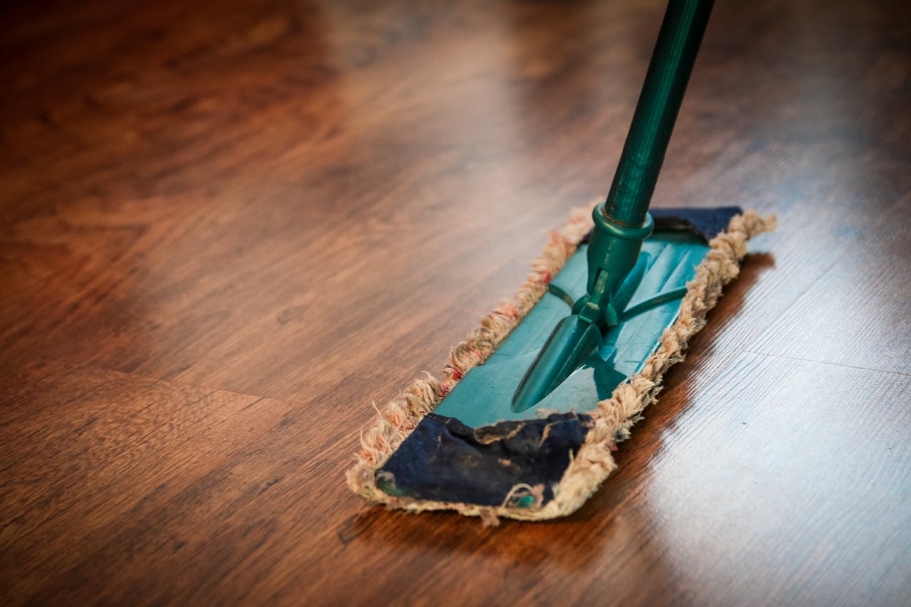 hero-img A detailed view of a mop cleaning a wooden floor, showing texture and pattern.